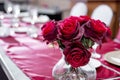 Closeup shot of a vase of red roses as decoration on a wedding table Royalty Free Stock Photo