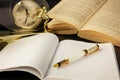 Closeup shot of a vintage quill pen on the copybook and an opene book in the background Royalty Free Stock Photo