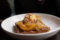 Closeup shot of a waffle with caramel apples and vanilla ice cream on a white plate Royalty Free Stock Photo