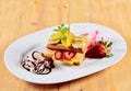 Closeup shot of waffles with strawberries and banana and ice cream on a white plate Royalty Free Stock Photo