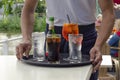 Closeup shot of the waiter bringing a tray of drinks