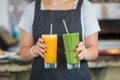 Closeup shot of waitress serving freshly made avocado and mango juices at cafe restaurant