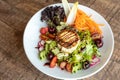 Closeup shot of a warm goats cheese salad served on a white plate