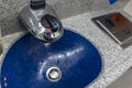 Closeup shot of the washbasin or sink of an aircraft lavatory, with a flush trash bin on the right