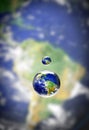 Water is the life-source of earth. Closeup shot of a water droplet above the earth. Royalty Free Stock Photo