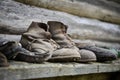 Closeup shot of weathered old farmer boots on a wooden panel