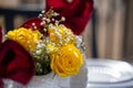 Closeup shot of a wedding bouquet with yellow roses put in a glass jar on the blurred background Royalty Free Stock Photo