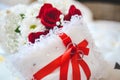 Closeup shot of wedding rings on a pillow with a red ribbon Royalty Free Stock Photo