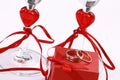 Closeup shot of wedding rings on a red box near heart glasses Royalty Free Stock Photo