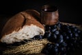 Closeup shot of wheat, white bread, grapes, and red wine in a wooden glass Royalty Free Stock Photo
