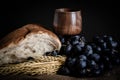 Closeup shot of wheat, white bread, grapes, and red wine in a wooden glass Royalty Free Stock Photo