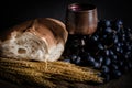 Closeup shot of wheat, white bread, grapes, and red wine in a wooden glass Royalty Free Stock Photo