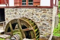 Closeup shot of a wheel in front of a wall in a garden Royalty Free Stock Photo