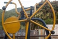 Closeup shot of a wheel-shaped yellow outdoor exercise equipment at a park