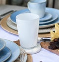 Closeup shot of white and blue empty glasses and plates on a white table Royalty Free Stock Photo