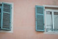 Closeup shot of white and blue windows on a pink wall Royalty Free Stock Photo