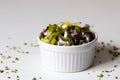 Closeup shot of a white bowl of a vegetable salad on a white surface Royalty Free Stock Photo