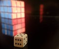 Closeup shot  of white dice with a blur Rubik's cube isolated on a black background Royalty Free Stock Photo