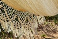 Closeup shot of a white knitted hammock with a design of macrame at the beach on a sunny day