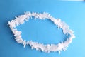 Closeup shot of a white plastic party necklace on a blue background Royalty Free Stock Photo