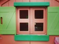 Closeup shot of a window of pink and green dollhouse Royalty Free Stock Photo