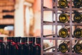 Closeup shot of wine shelf. Bottles lay over straw. Wine cellar