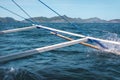 Closeup shot of the wing part of the boat in the ocean of waves in front of the mountains