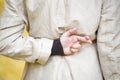 Closeup shot of a woman crossing her fingers behind her back on a yellow background