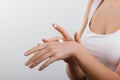 Closeup shot of woman hands holding cream and applying moisturizing hand cream. Beautiful female hands with cream. Royalty Free Stock Photo