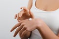 Closeup shot of woman hands holding cream and applying moisturizing hand cream. Beautiful female hands with cream. Royalty Free Stock Photo