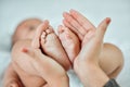 The smallest feet leave the biggest footprints on your heart. Closeup shot of a woman holding up her babys tiny feet. Royalty Free Stock Photo