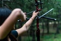 Closeup shot of a woman hunter aiming with bow and arrow in a forest Royalty Free Stock Photo