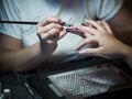 Woman in a nail salon receiving a manicure by a beautician with nail file woman