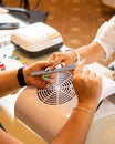 Closeup shot of a woman in a nail salon receiving a manicure by a beautician with nail file Royalty Free Stock Photo