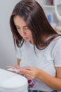 Closeup shot of woman in nail salon receiving manicure by beautician with nail file and machine. Woman getting nail Royalty Free Stock Photo