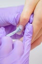 Closeup shot of woman in nail salon receiving manicure by beautician with nail file and machine. Woman getting nail Royalty Free Stock Photo