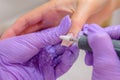 Closeup shot of woman in nail salon receiving manicure by beautician with nail file and machine. Woman getting nail Royalty Free Stock Photo