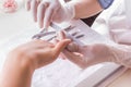 Closeup shot of a woman in a nail salon receiving a manicure by a beautician with nail file Royalty Free Stock Photo