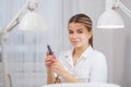 Closeup shot of woman in nail salon receiving manicure by beautician with nail file and machine. Woman getting nail Royalty Free Stock Photo