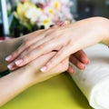 Closeup shot of a woman in a nail salon receiving a manicure by a beautician with nail file. Woman getting nail manicure Royalty Free Stock Photo