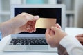 Closeup shot of a woman`s hand giving a payment credit card to the seller in computer store. . Shallow depth of field Royalty Free Stock Photo