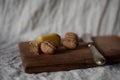 Closeup shot of a wooden board with nuts cheese and knife on it, breakfast Royalty Free Stock Photo