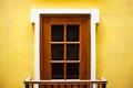 Closeup shot of a wooden door with windows on a yellow wall - great for a cool background Royalty Free Stock Photo