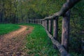 Closeup shot of a wooden fence and a path in an autumn park Royalty Free Stock Photo