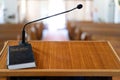 Closeup shot of a wooden pulpit with a microphone and a black bible