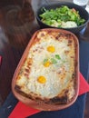 Closeup shot of a wooden table has vegetable salad and a meal baked and made in oven with eggs