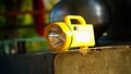Closeup shot of Yellow Battery on the rough column. Electric chargeable search light torch with handle Royalty Free Stock Photo