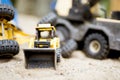 Closeup shot of a yellow bulldozer on a sandy surface with a blurred background