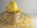 Closeup shot of a yellow decorative Easter egg and flowers in a small straw basket Royalty Free Stock Photo