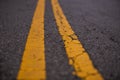 Closeup shot of the yellow dividing lines on a road. Royalty Free Stock Photo